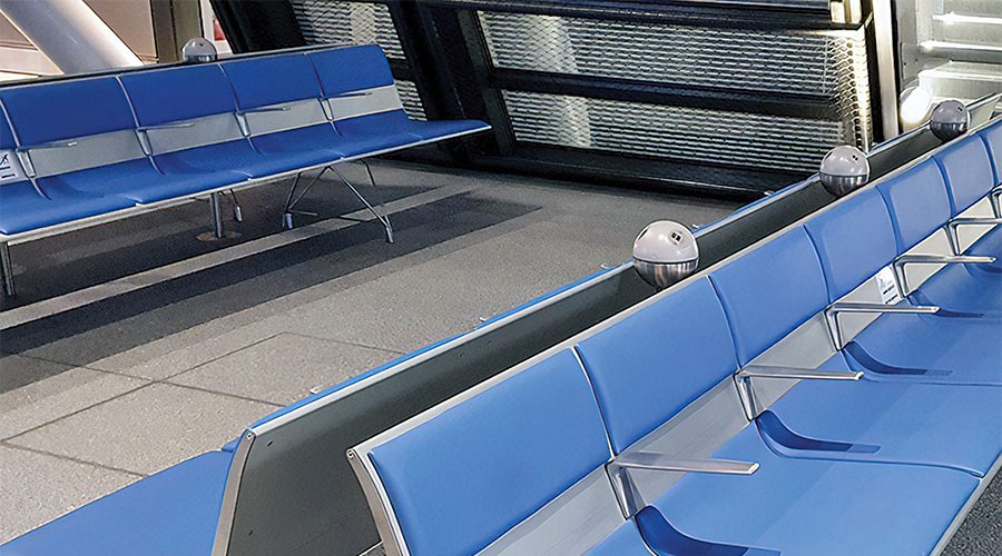 A bank of seats in Geneva Airport. The seats are blue and have PLUTO built into them